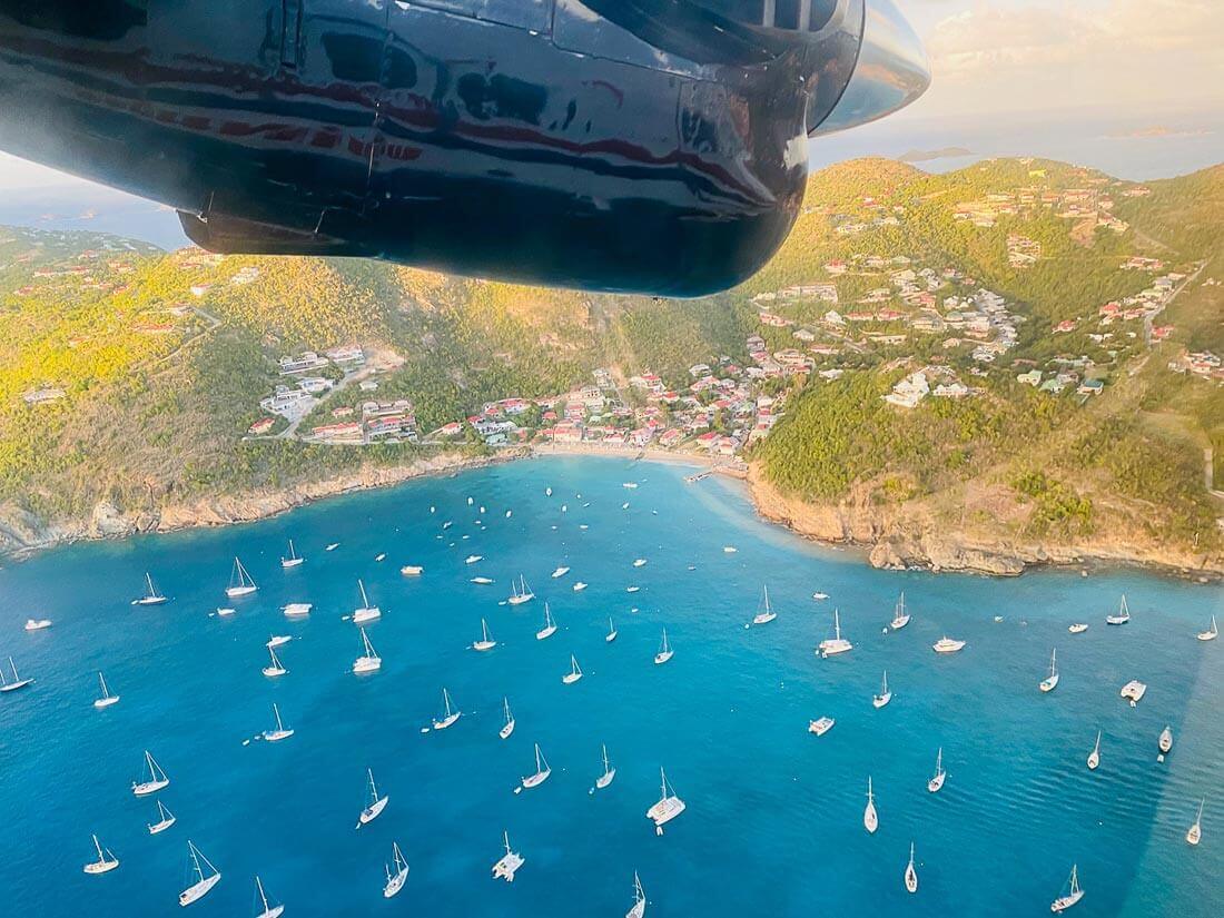 St. Barths Guide plane flying over the yachts in the bay.