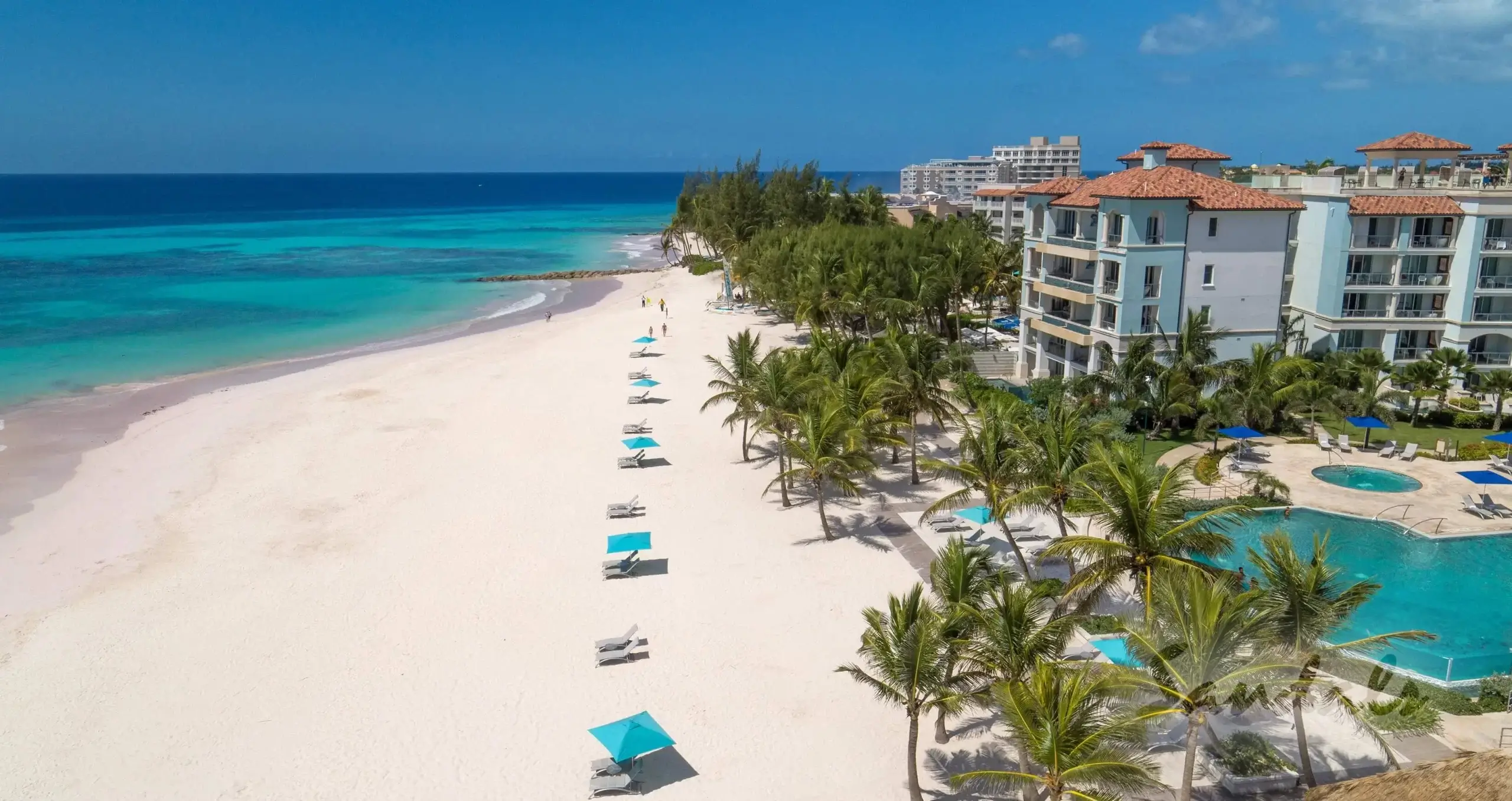 Sandals Barbados white sand beach with clear water and swimming pool.