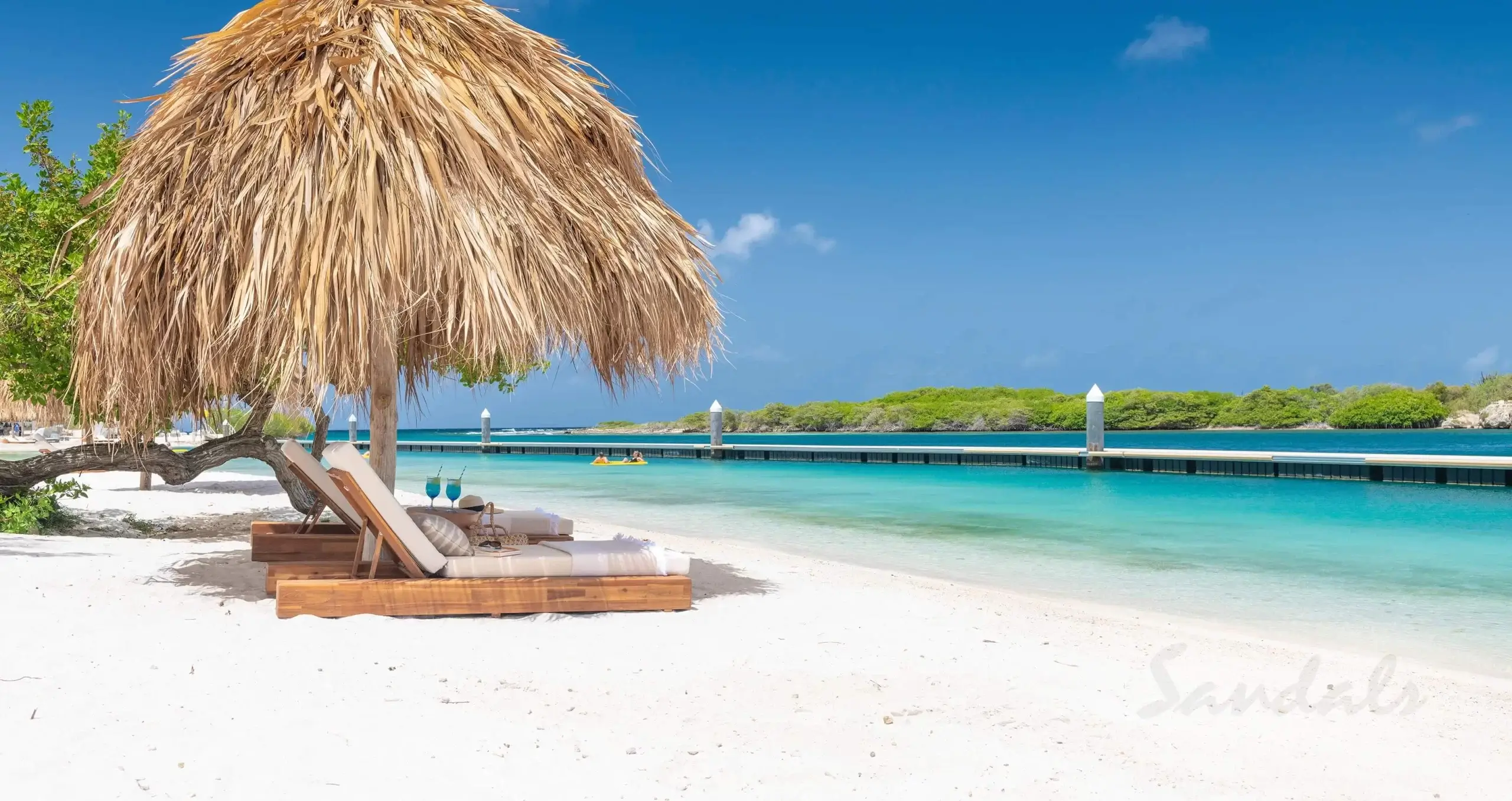 Private beach palapa at sandals curacao with white sand and clear water.